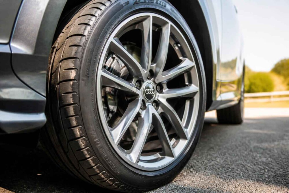 Zbliżenie na aluminiowe koło samochodu Audi z oponą na drodze grasowej